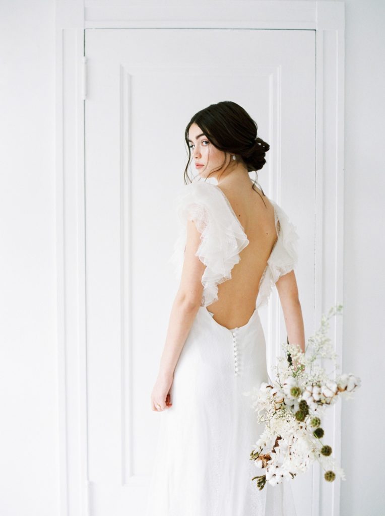 Wedding event planner Vancouver ethereal wedding bride with netural toned bouquet looking over her shoulder