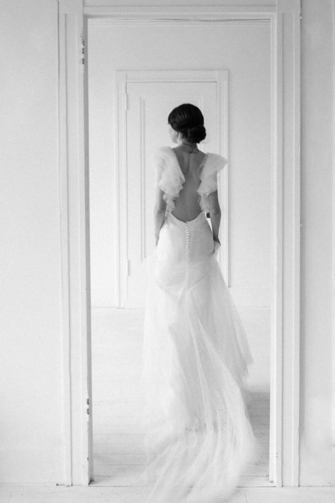 Wedding event planner Vancouver ethereal wedding bride walking through doorway in black and white