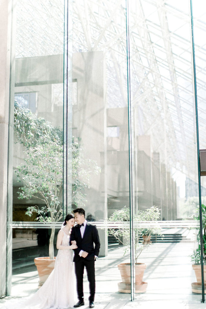 Rosewood Hotel Georgia Wedding couple portraits with linked arms in the glass room
