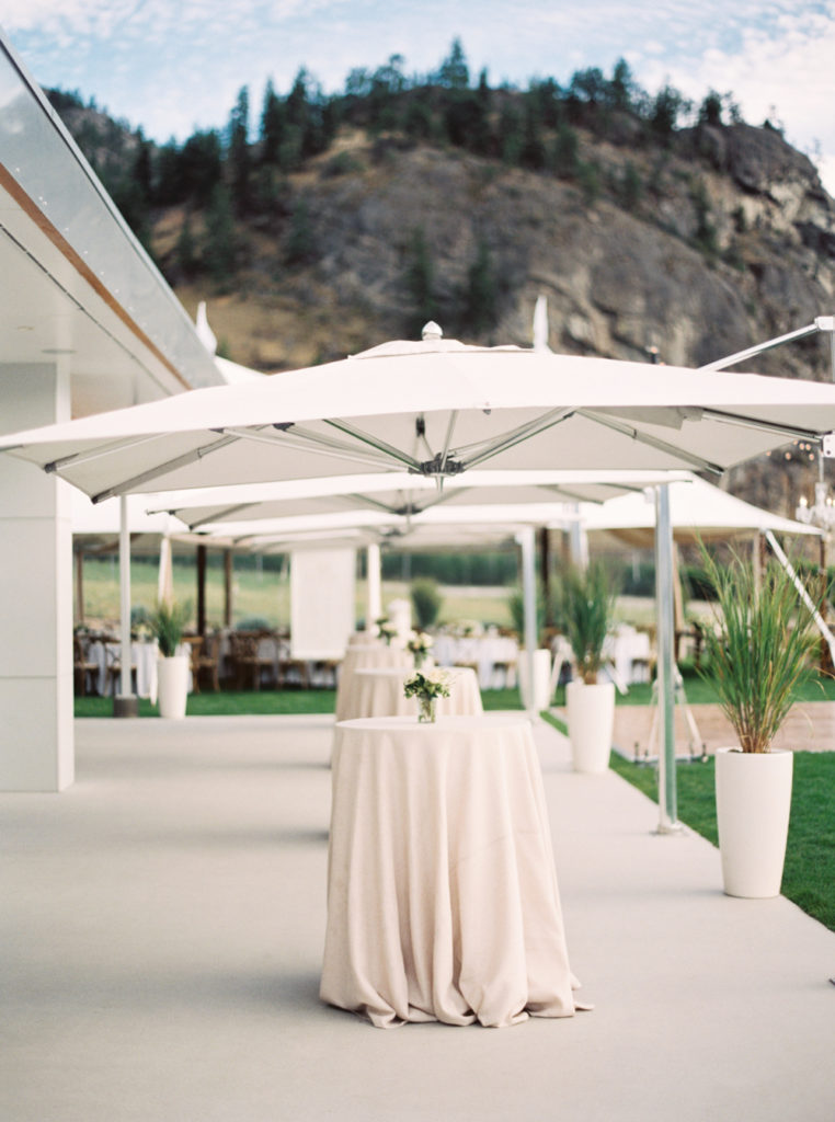White cocktail tables and umbrellas