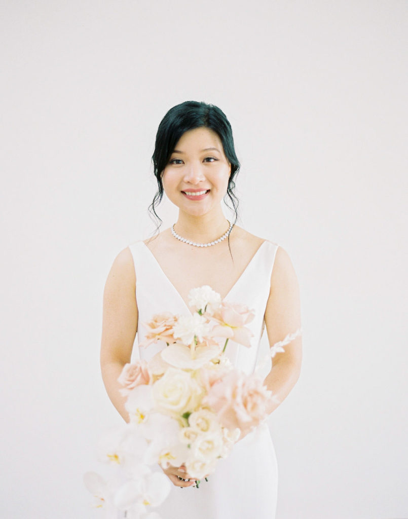 Smiling bride holding a pastel bouquet
