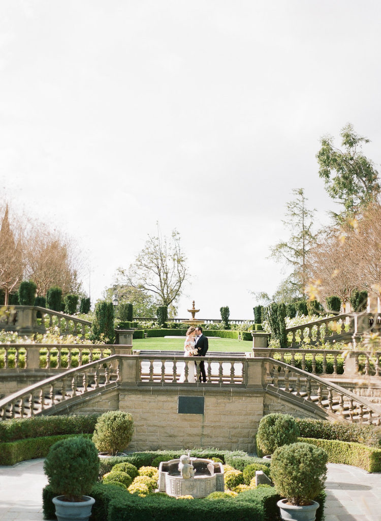 Couple posing at top of Greystone mansion staircase