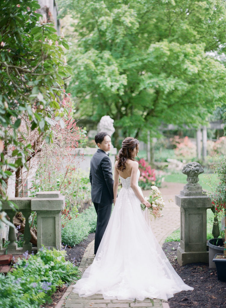 bride and groom walking in rose garden