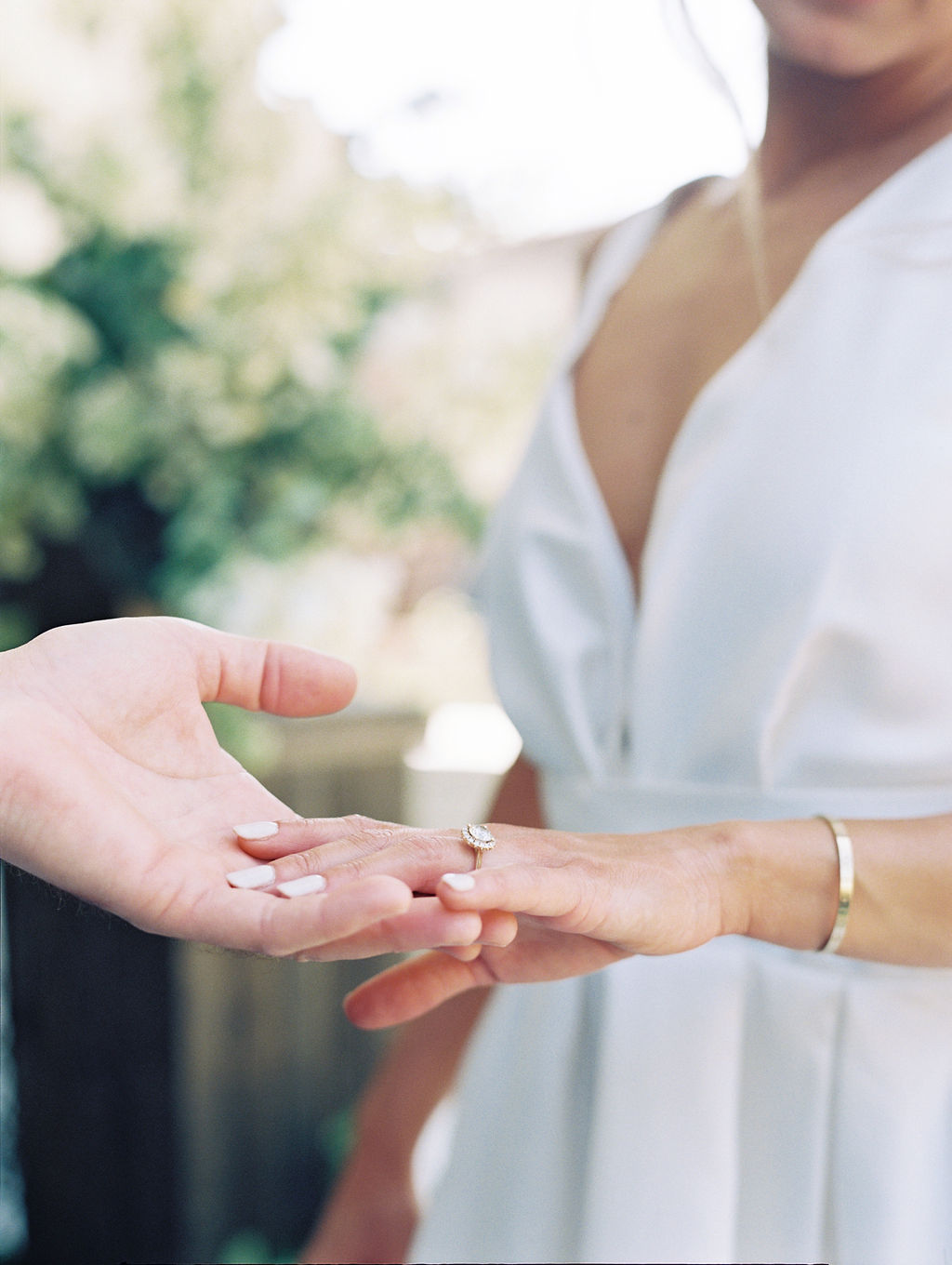 groom holding bride's hand with ring