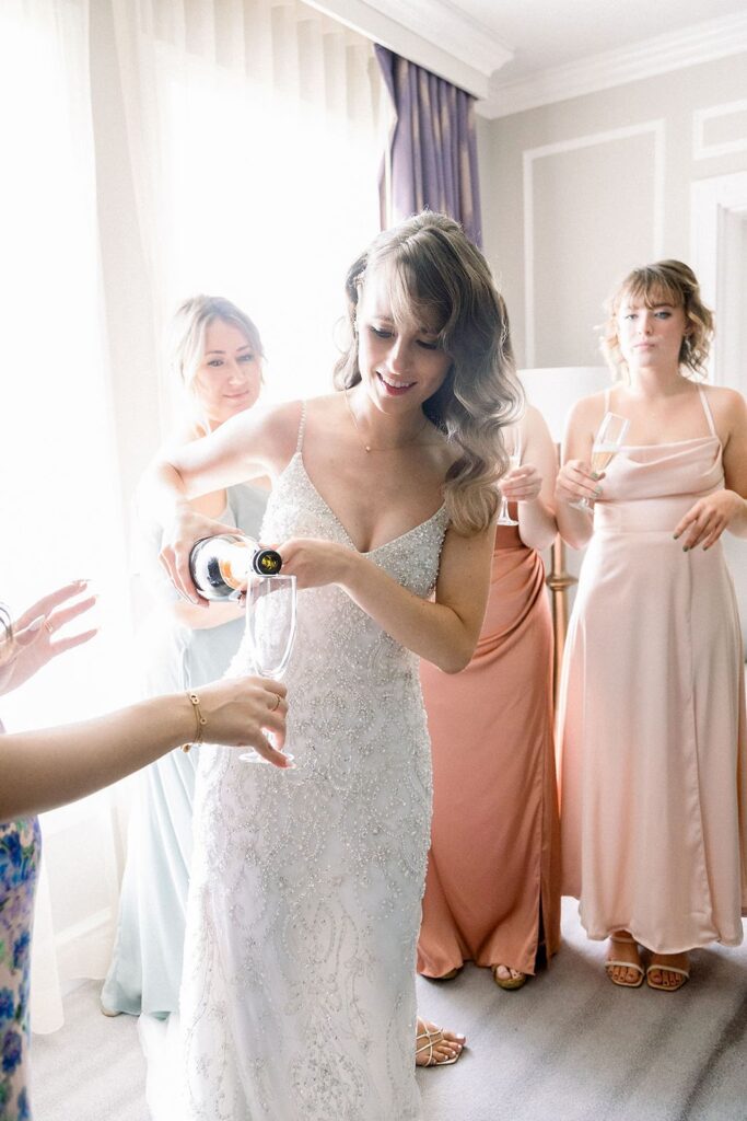 bride pouring champagne for bridesmaids
