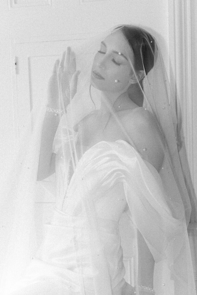 black and white photo of bride with veil