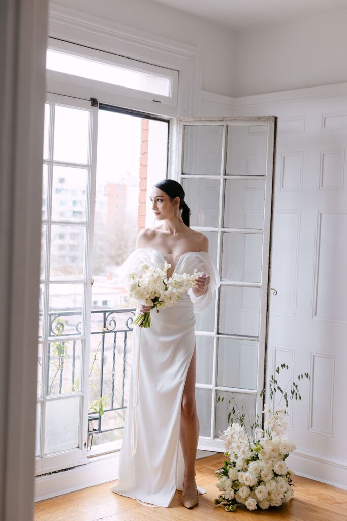 bride holding bouquet by window