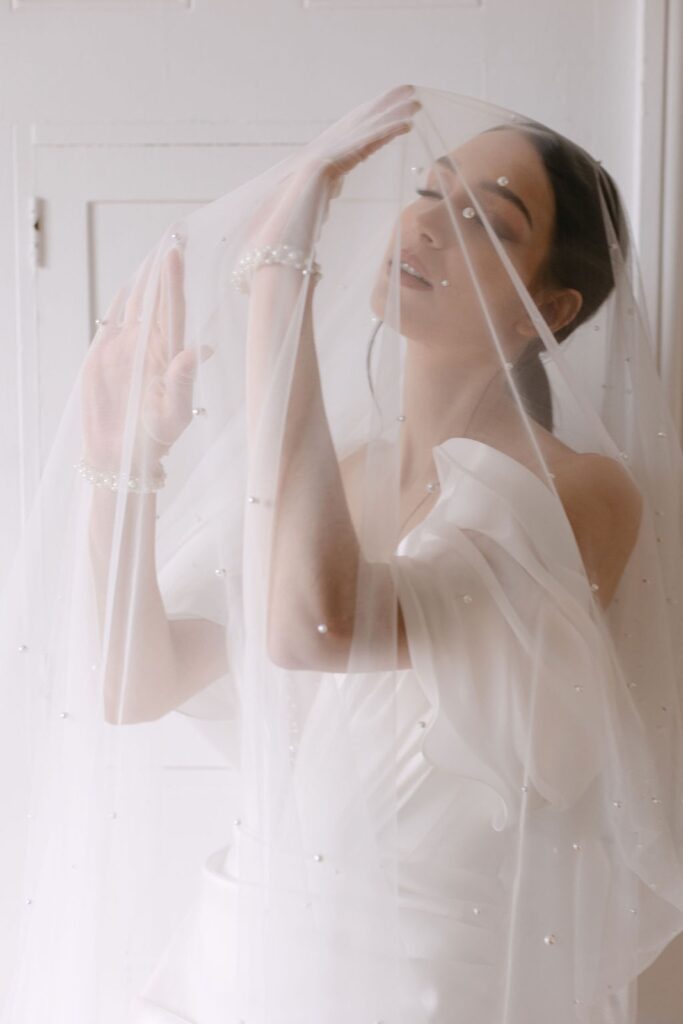 bride posing under veil