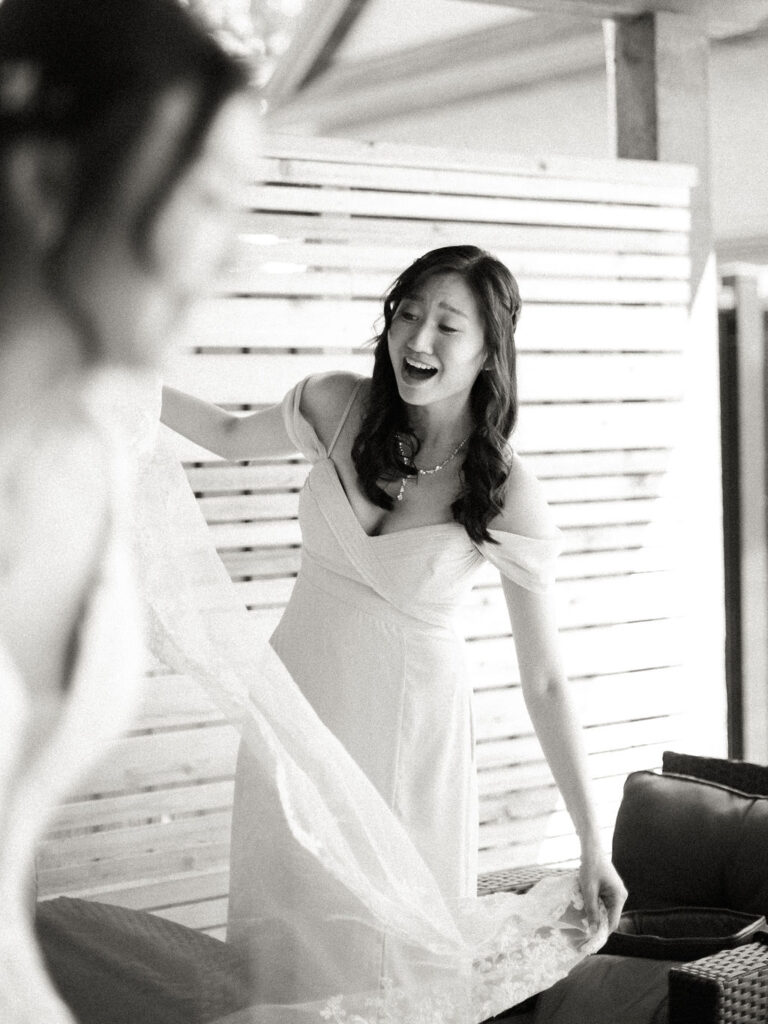 bridesmaid helping bride with dress