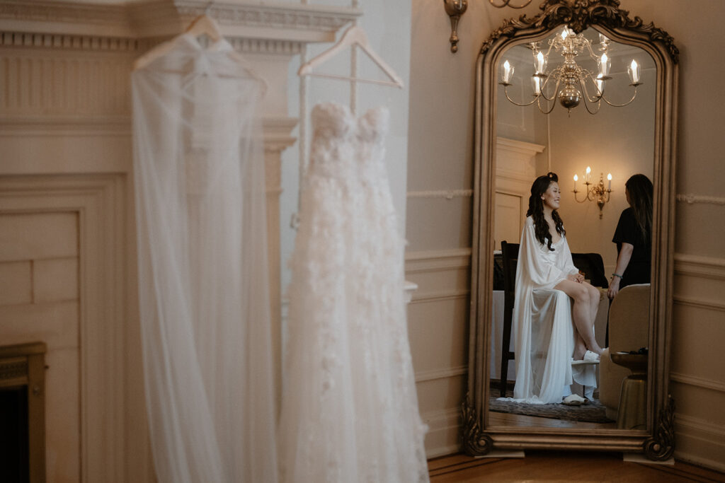 Bride's reflection in mirror on makeup chair