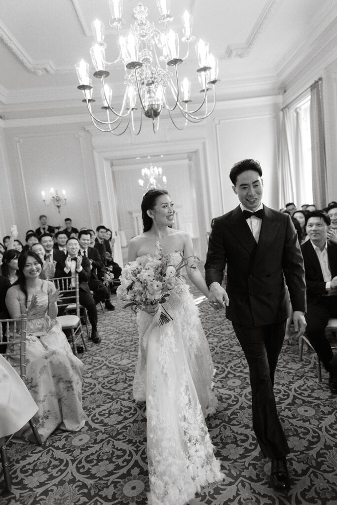 Couple walking out as newlyweds in Georgian Room