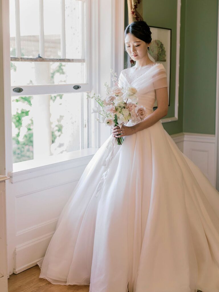 bride holding bouquet in upstairs Hycrof room