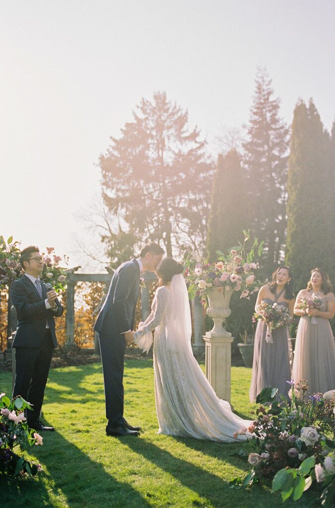 newlyweds kiss in rose garden at hycroft