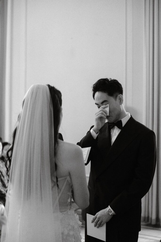 groom wiping tears at ceremony